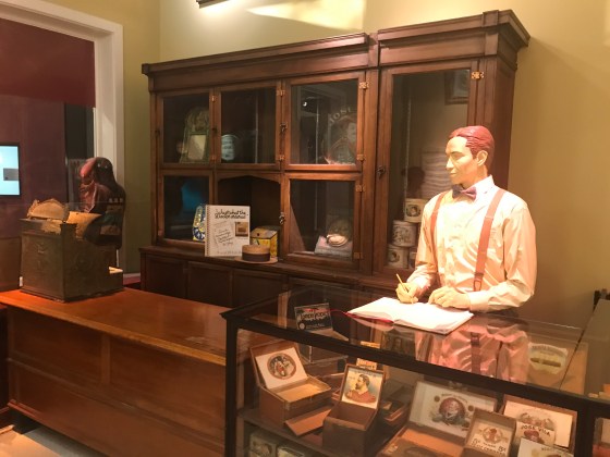 A lesson on the history of cigar advertising in a cigar shop